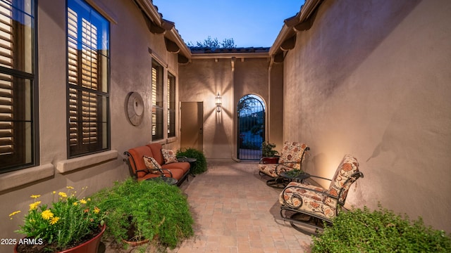 entrance to property with stucco siding and a patio area