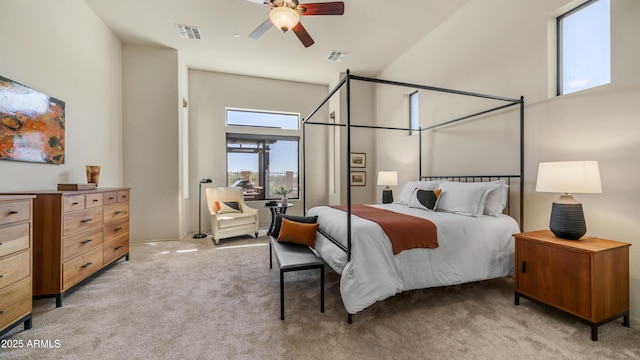 bedroom with light colored carpet, visible vents, a high ceiling, and a ceiling fan
