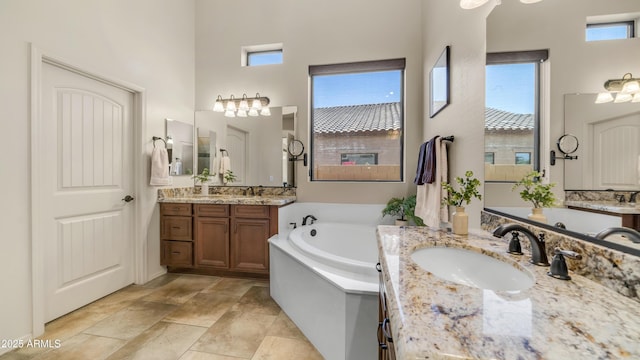 full bath with a high ceiling, a sink, two vanities, and a garden tub