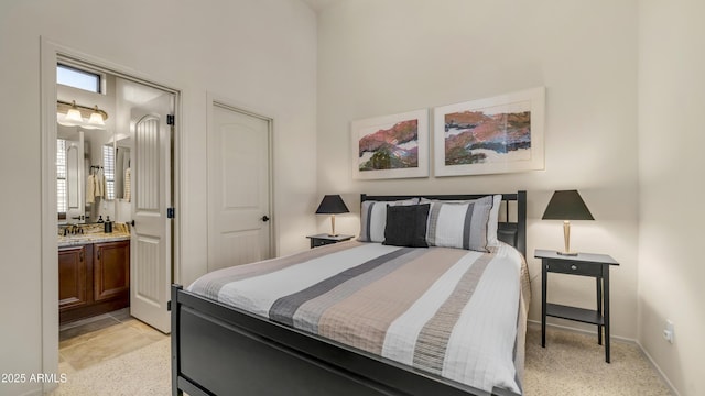 bedroom featuring baseboards, a high ceiling, and ensuite bath