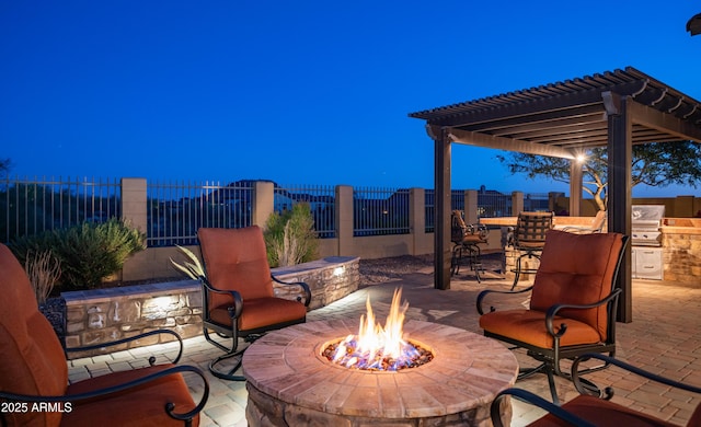 view of patio with an outdoor fire pit, fence private yard, exterior kitchen, and a pergola