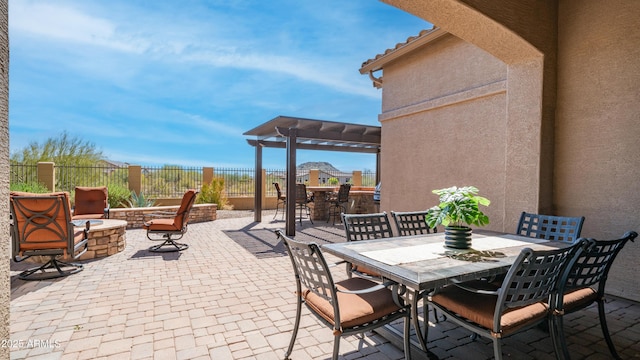 view of patio with outdoor dining area, fence, an outdoor fire pit, and a pergola