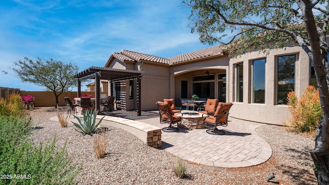 rear view of house with fence, a tiled roof, an outdoor fire pit, a pergola, and a patio area