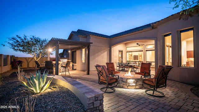 view of patio / terrace featuring outdoor dining space, a fire pit, fence, and a pergola