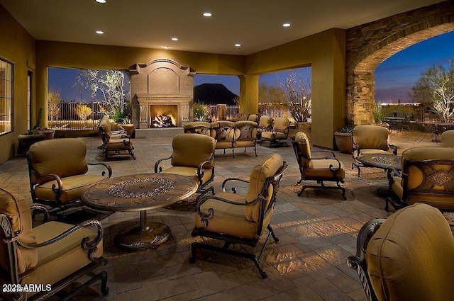 patio terrace at dusk with an outdoor living space with a fireplace