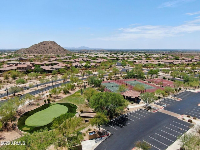 drone / aerial view with view of golf course, a residential view, and a mountain view