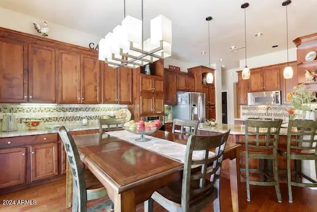 dining room with dark wood-type flooring and an inviting chandelier