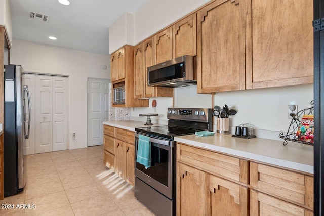 kitchen with appliances with stainless steel finishes and light tile patterned flooring