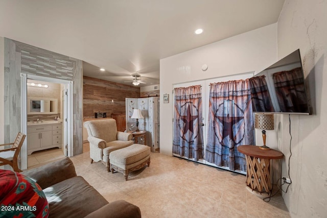 living room featuring ceiling fan and wood walls