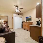 interior space featuring ceiling fan and light colored carpet