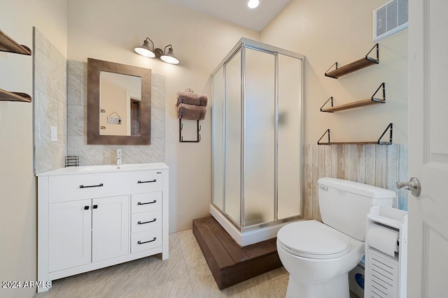 bathroom with vanity, toilet, and a shower with door