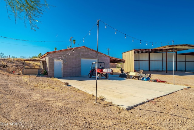 rear view of property featuring a carport, an outdoor structure, and a garage