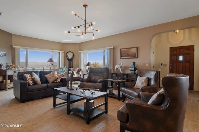 living room featuring a wealth of natural light, light hardwood / wood-style flooring, a chandelier, and a mountain view