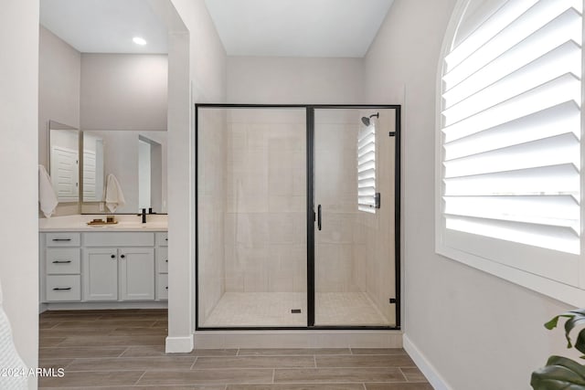 bathroom with a shower with door and vanity