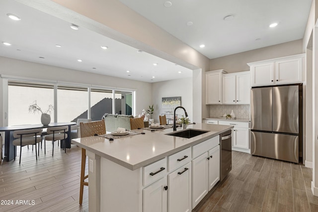 kitchen featuring white cabinets, appliances with stainless steel finishes, and a kitchen island with sink