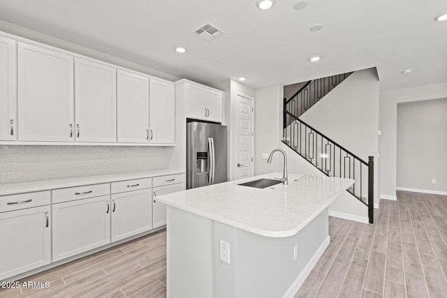 21047 N 58th Way, Phoenix, AZ 85054 - kitchen with stainless steel fridge, a sink, light wood-type flooring, white cabinets, and baseboards