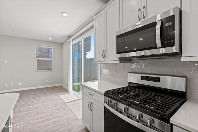 21047 N 58th Way, Phoenix, AZ 85054 - kitchen with appliances with stainless steel finishes, backsplash, baseboards, light wood-style flooring, and recessed lighting