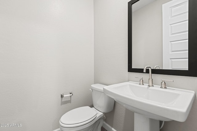 21047 N 58th Way, Phoenix, AZ 85054 - half bathroom with baseboards, toilet, and a sink