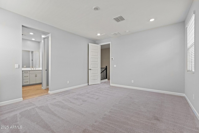 21047 N 58th Way, Phoenix, AZ 85054 - unfurnished bedroom with light colored carpet, baseboards, recessed lighting, ensuite bathroom, and a sink