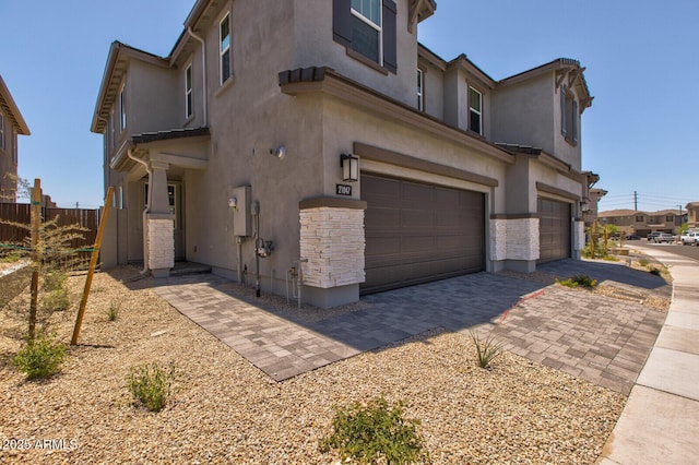 21047 N 58th Way, Phoenix, AZ 85054 - view of property exterior featuring a garage, stucco siding, and decorative driveway