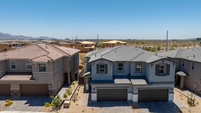 21047 N 58th Way, Phoenix, AZ 85054 - view of front of property featuring an attached garage, stucco siding, a residential view, driveway, and stone siding