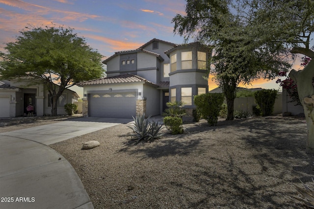 18103 W Canyon Ln, Goodyear, AZ 85338 - view of front of house with stucco siding, a tile roof, driveway, stone siding, and a garage