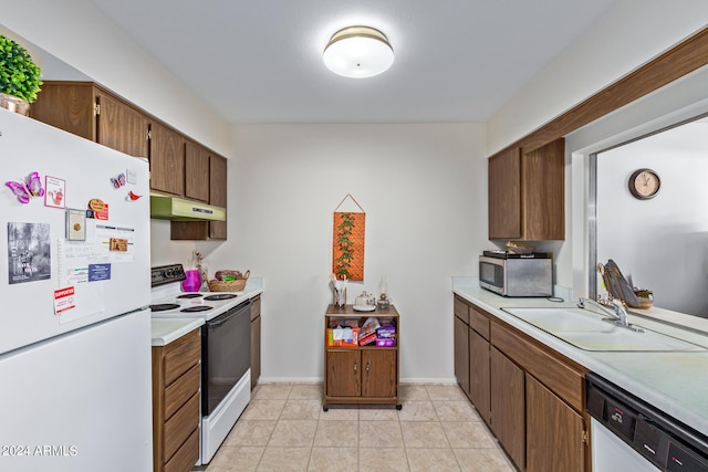 kitchen featuring white appliances, light tile patterned floors, light countertops, under cabinet range hood, and a sink