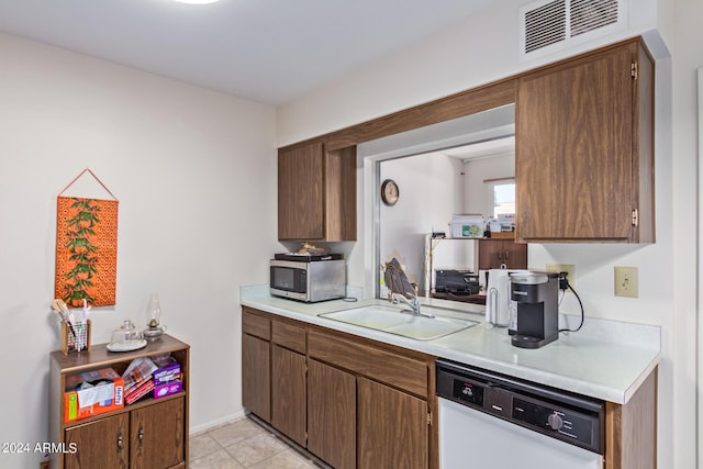 kitchen featuring white dishwasher, a sink, visible vents, light countertops, and stainless steel microwave