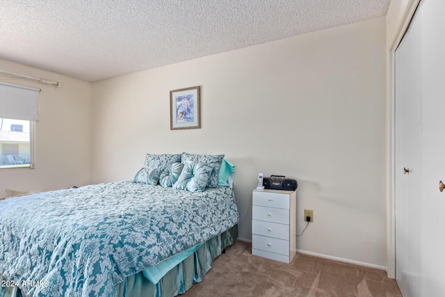 carpeted bedroom featuring a closet and a textured ceiling