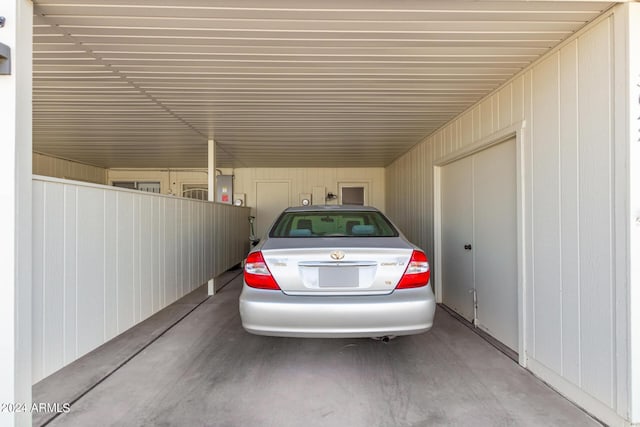 view of parking featuring an attached carport and electric panel