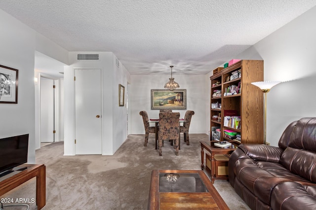 living area featuring carpet floors, visible vents, and a textured ceiling