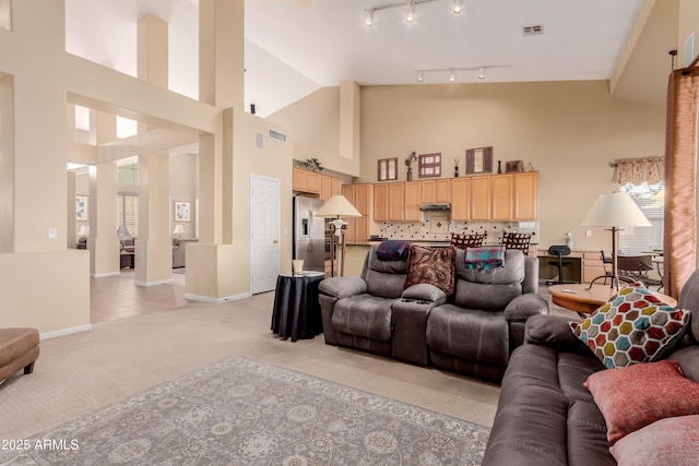 living room with light colored carpet and a towering ceiling