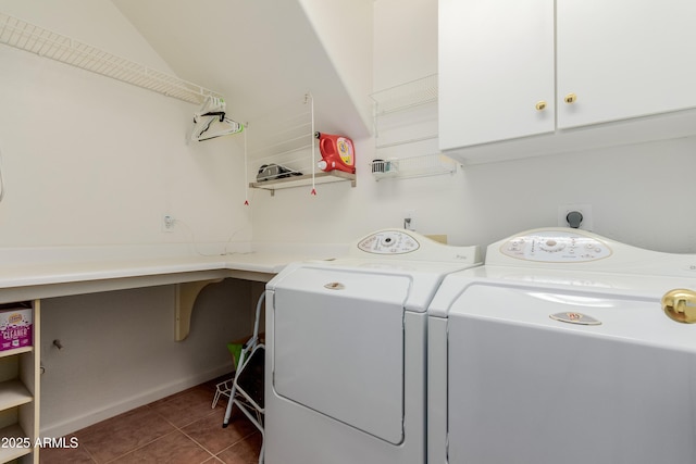 laundry area with washing machine and dryer, cabinets, and dark tile patterned floors