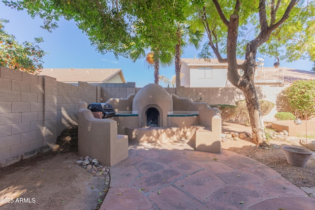 view of patio featuring exterior fireplace and area for grilling