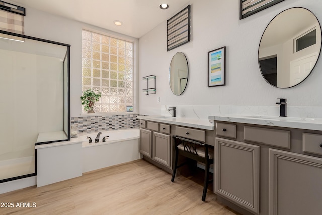 bathroom featuring hardwood / wood-style flooring, a washtub, and vanity