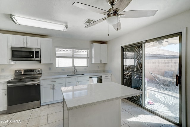 kitchen featuring a wealth of natural light, sink, appliances with stainless steel finishes, and white cabinetry