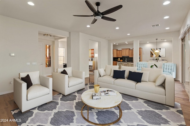 living room featuring hardwood / wood-style floors and ceiling fan