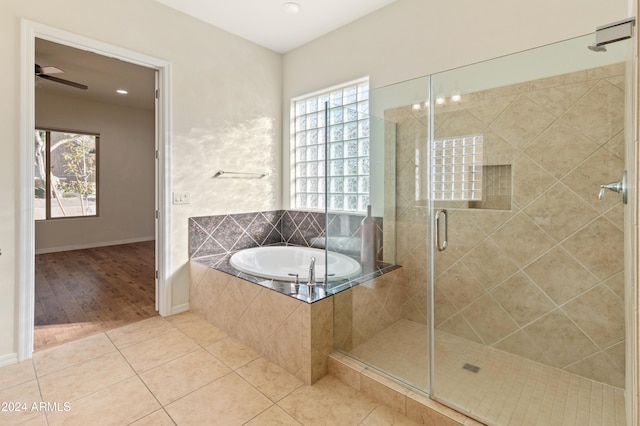 bathroom featuring a wealth of natural light, a shower stall, a bath, and tile patterned floors