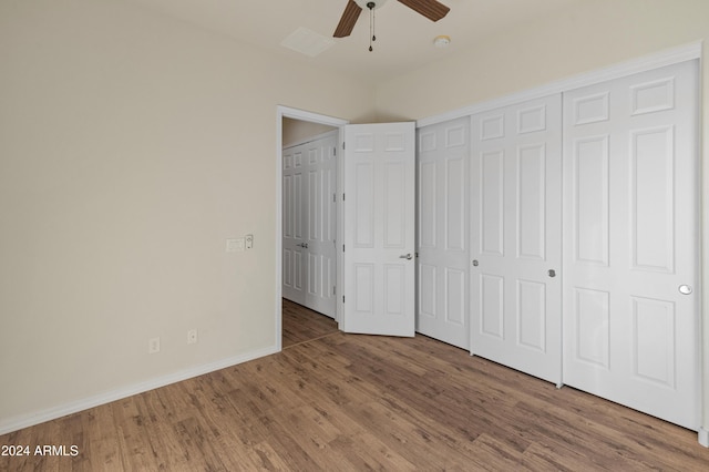 unfurnished bedroom featuring hardwood / wood-style flooring, ceiling fan, and a closet