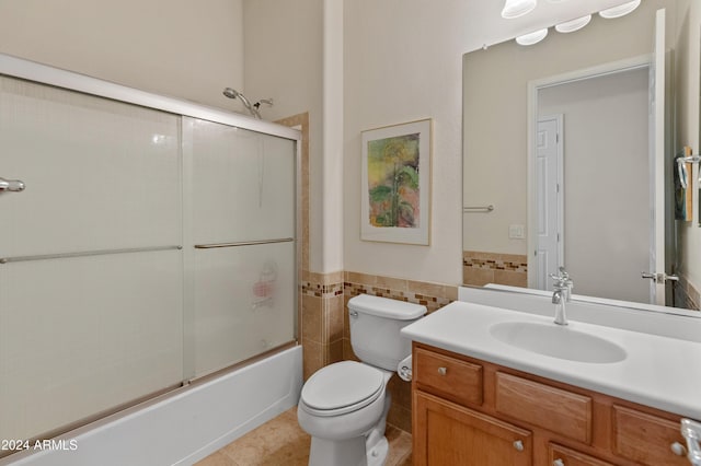 full bathroom with vanity, tile walls, enclosed tub / shower combo, tile patterned flooring, and toilet