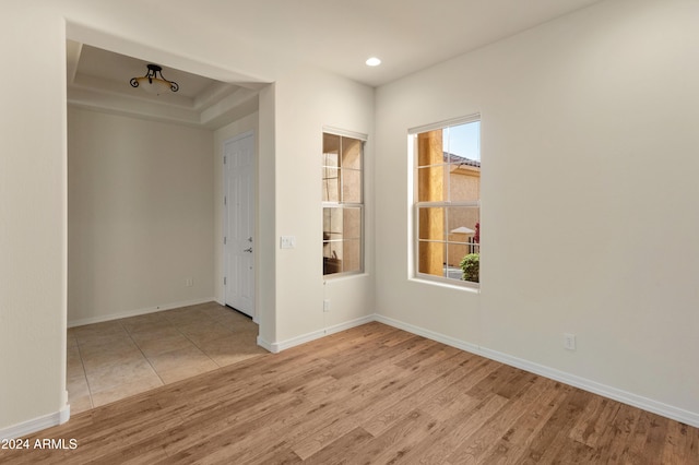 empty room with wood finished floors, a wealth of natural light, and baseboards