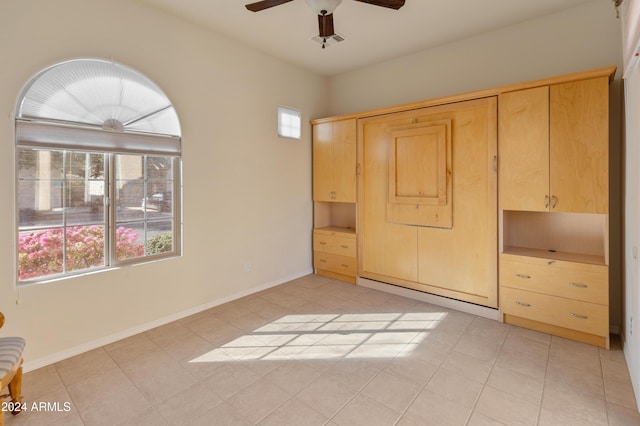 unfurnished bedroom featuring a ceiling fan, visible vents, baseboards, and light tile patterned floors