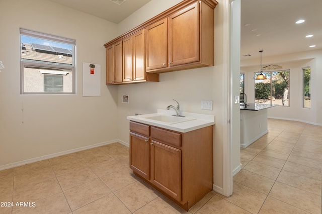 washroom featuring light tile patterned floors, hookup for a washing machine, recessed lighting, a sink, and baseboards