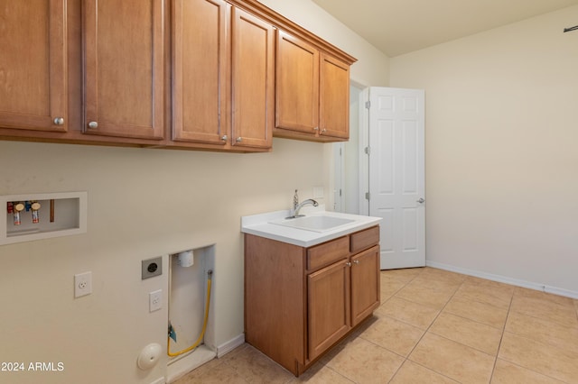 laundry area with cabinets, hookup for a washing machine, electric dryer hookup, sink, and light tile patterned floors