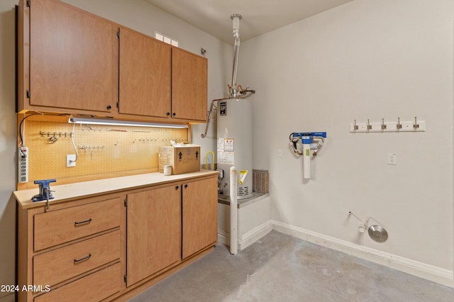 washroom featuring water heater and baseboards