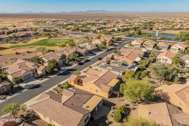 drone / aerial view featuring a residential view, view of golf course, and a water and mountain view