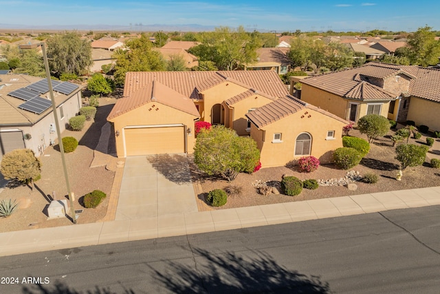 view of front facade with a garage, concrete driveway, a residential view, a tiled roof, and stucco siding