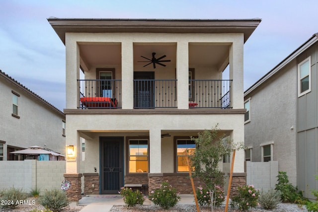 view of front facade featuring ceiling fan and a balcony