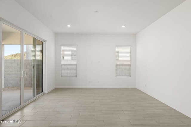 empty room with recessed lighting and baseboards