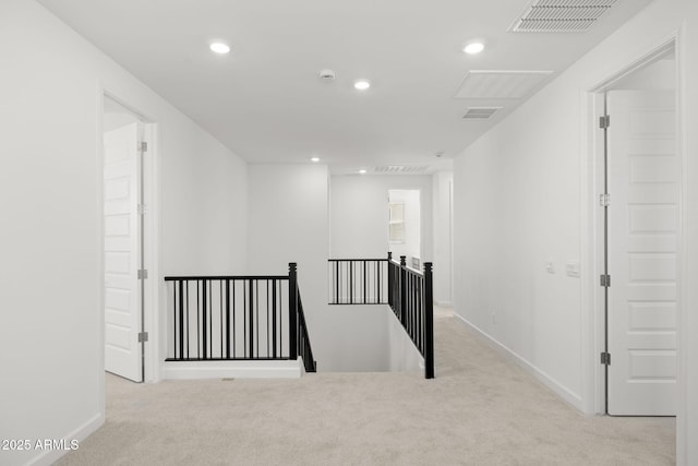 corridor featuring visible vents, baseboards, carpet floors, and an upstairs landing